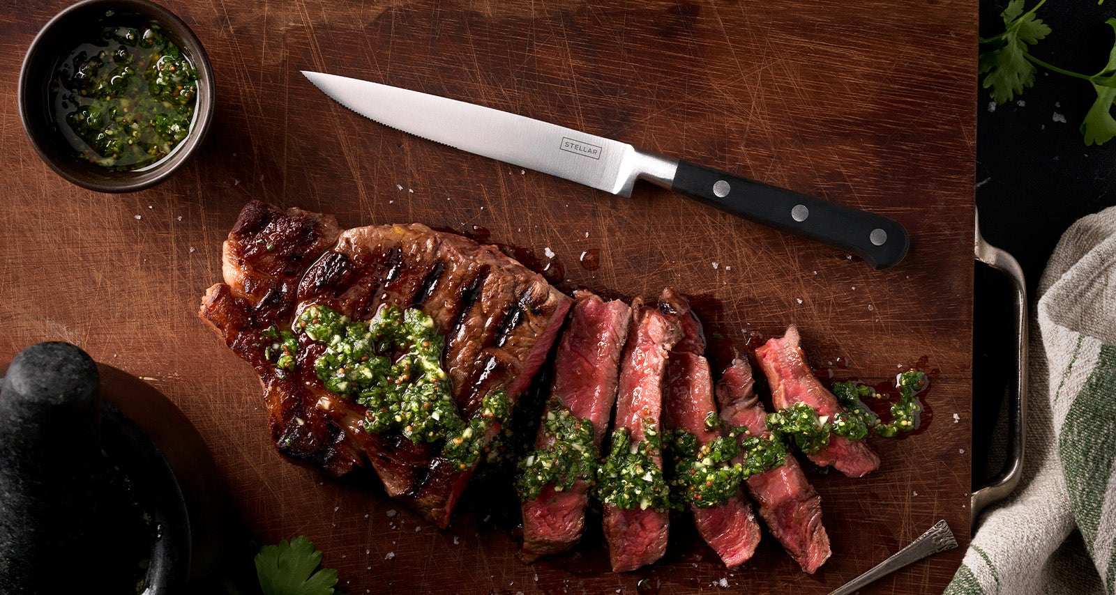 Stellar Classic Steak Knife on chopping board next to sliced steak